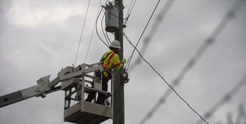 Lineman hanging fiber cables in Macon County, Alabama